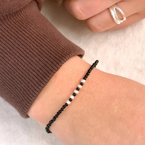 sort armband med onyxer og 5 sötvattenspärlor.