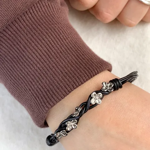 Svart armband i läder med blommaberlock i rhodinerat silver