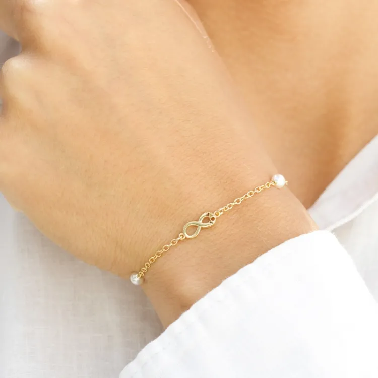 infinity armband i förgyllt silver med hängen i förgyllt silver